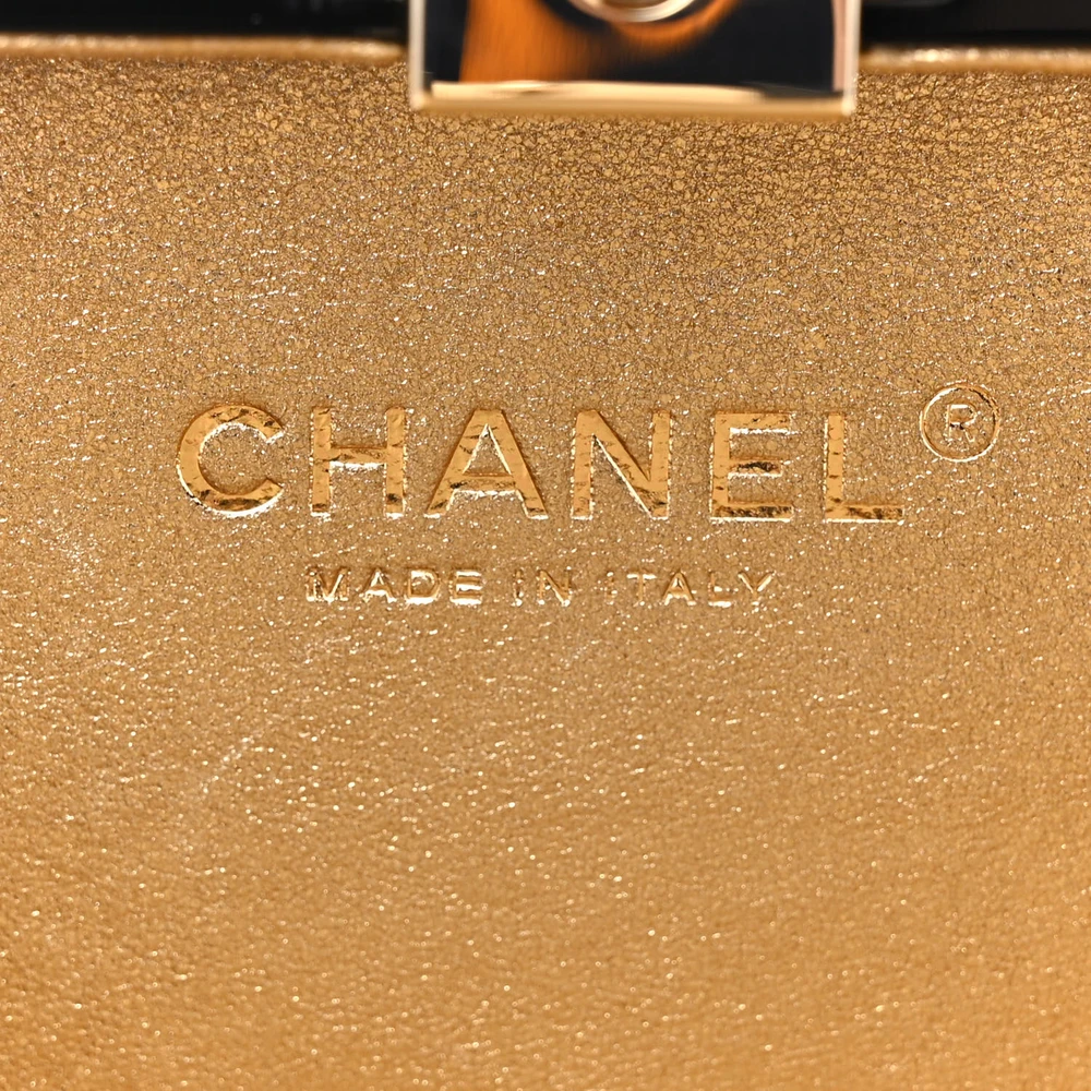 Close-up of the gold-tone hardware and decorative details on the black plexiglass Perfume Bottle Clutch