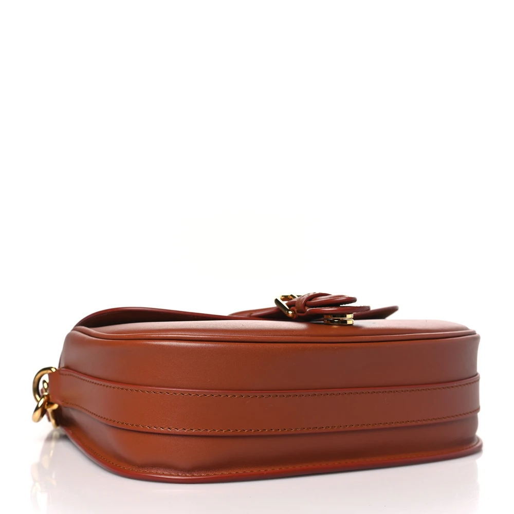Bottom view of the camel box calfskin D!0r Medium Bobby Flap Bag showing the structured leather base