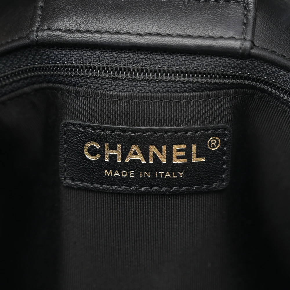 Close-up of the CC logo and gold-tone hardware on the black quilted calfskin Large Classic Shopping Tote