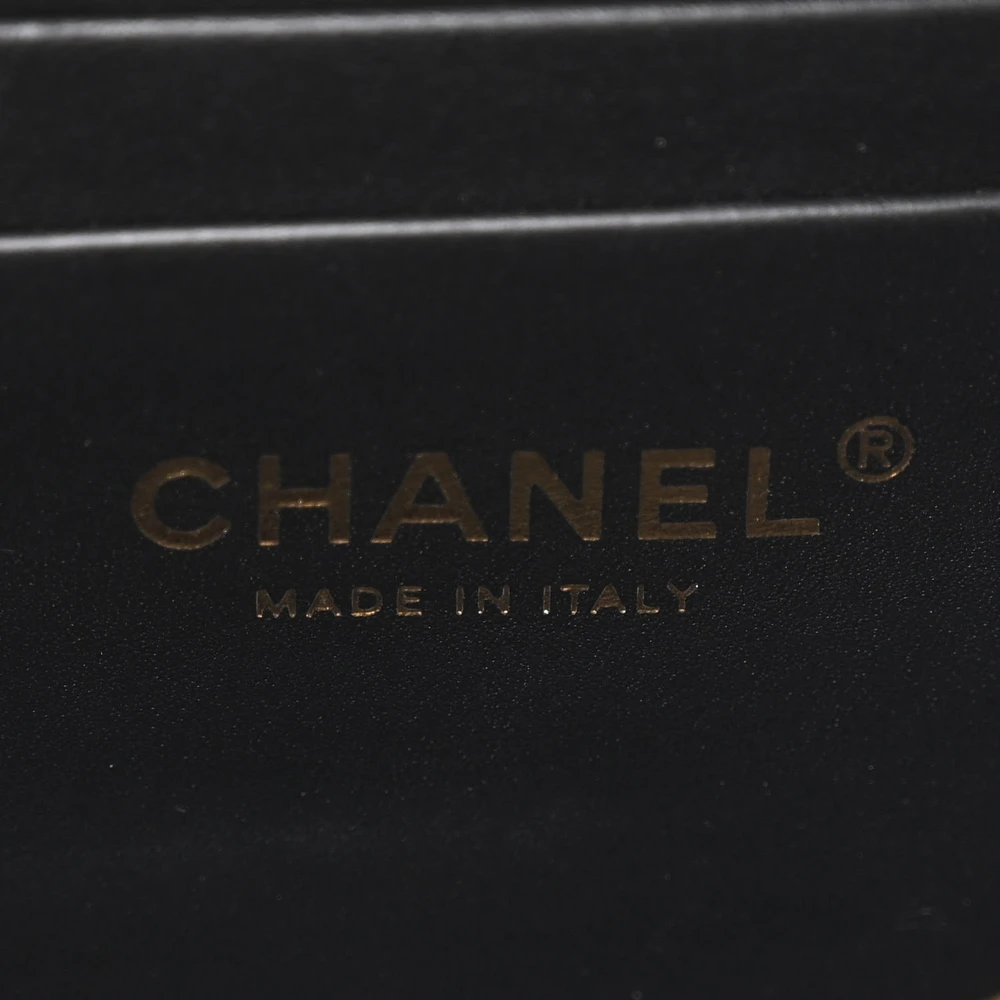 Close-up of the CC logo and gold-tone hardware on the black caviar leather Mini Camera Case