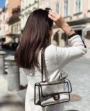 Model carrying the black PVC Ch@nel Sand By The Sea Flap with faux pearl shoulder strap