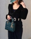Model carrying a dark green Cannage lambskin Mini Lady bag with top handles and shoulder strap