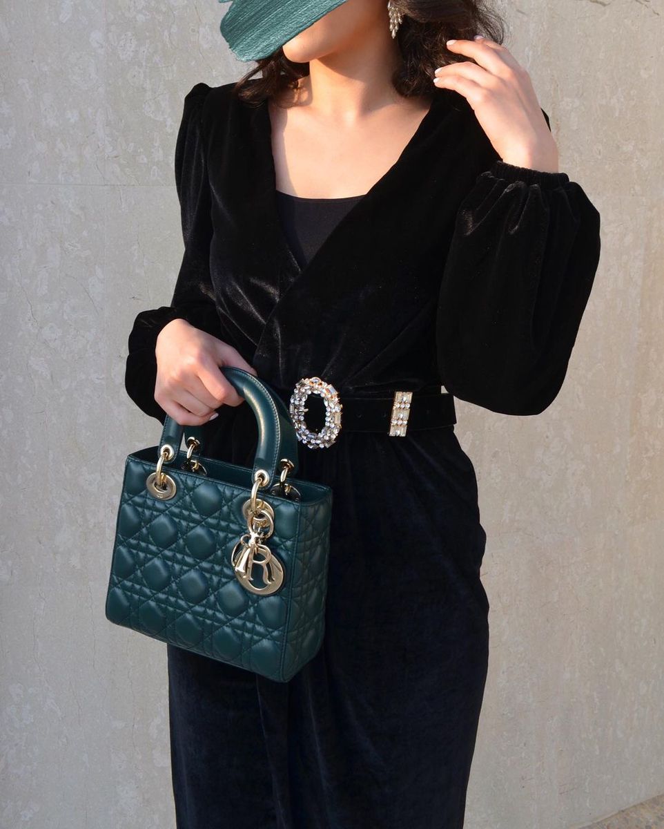 Model carrying a dark green Cannage lambskin Mini Lady bag with top handles and shoulder strap