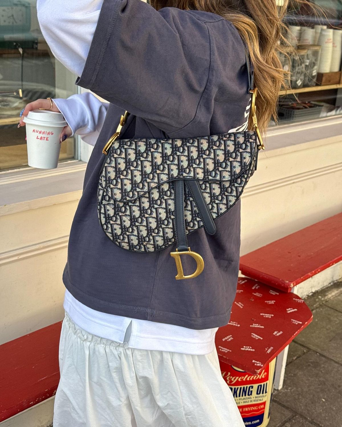 Model carrying a blue Oblique jacquard Mini Saddle bag with adjustable shoulder strap