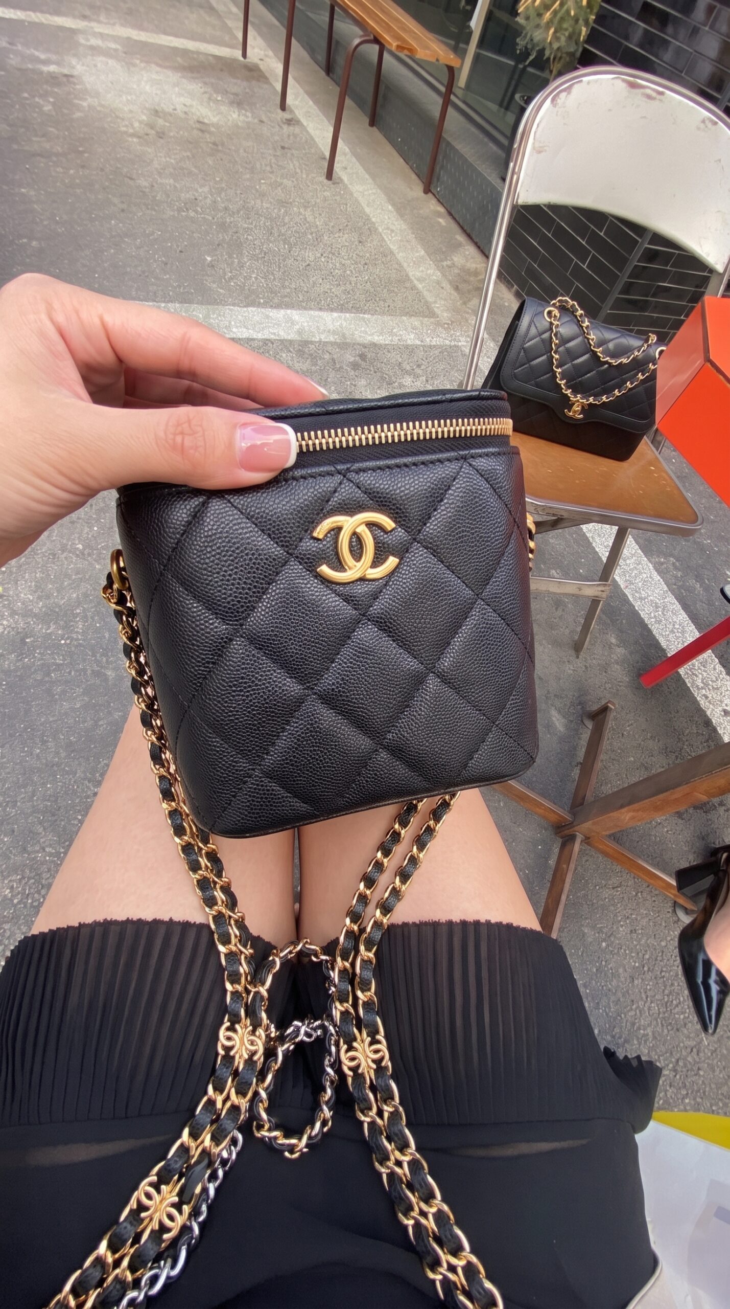 Model carrying the black caviar leather Small Coco Beauty Vanity Case with gold-tone chain strap