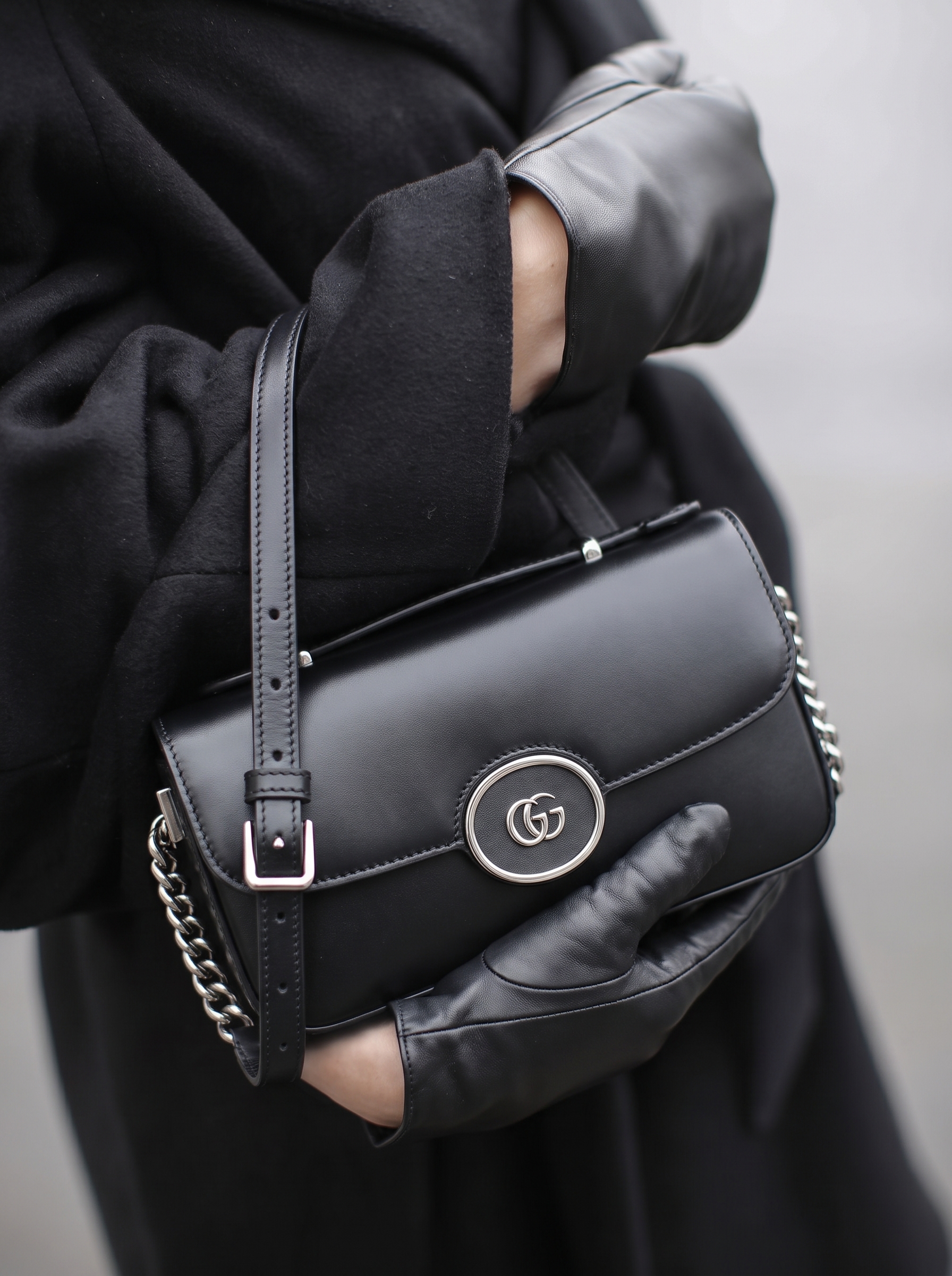 Model carrying a Gucc! black Senna calfskin Petite GG top handle shoulder bag