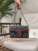 Model carrying an electric blue New Denim GG monogram Super Mini Dionysus shoulder bag