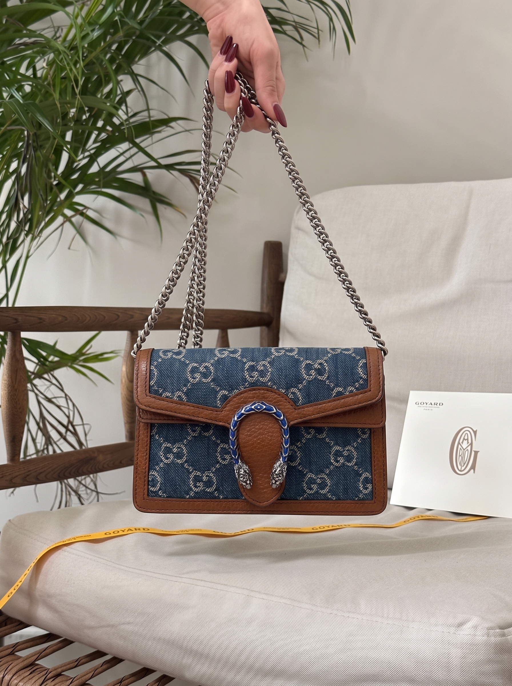 Model carrying an electric blue New Denim GG monogram Super Mini Dionysus shoulder bag