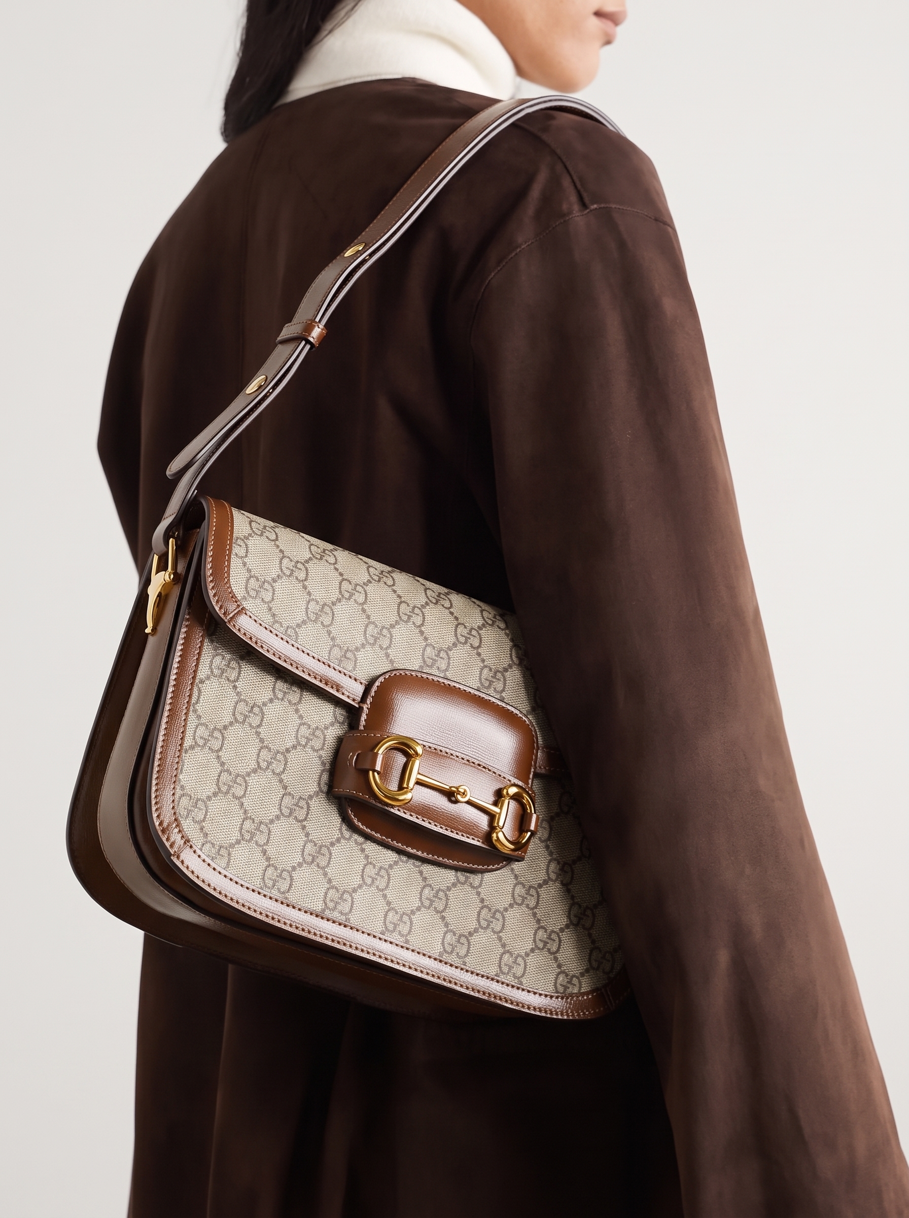 Model carrying a beige GG Supreme monogram Mini Horsebit 1955 shoulder bag with Brown Sugar leather trim