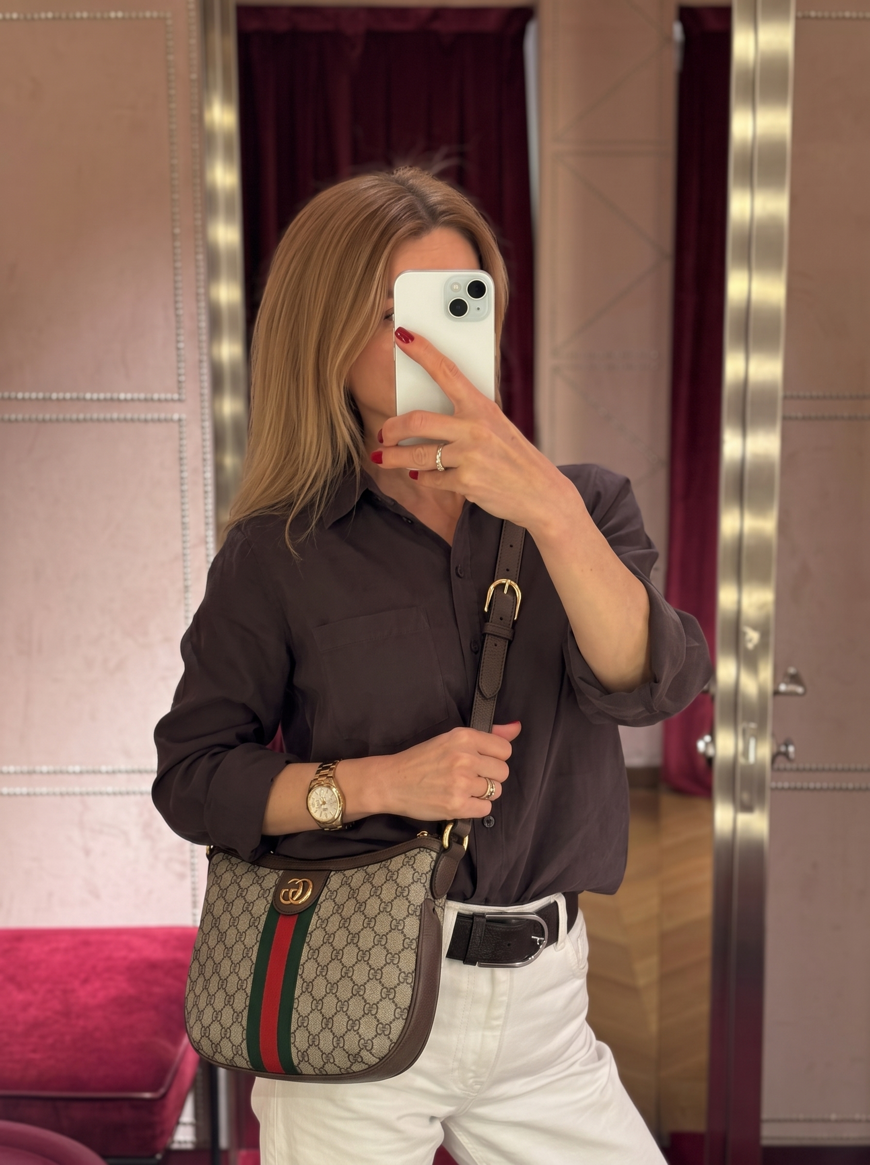 Model carrying a GG Supreme monogram Small OphidiaHalf Moon Hobo with leather shoulder strap