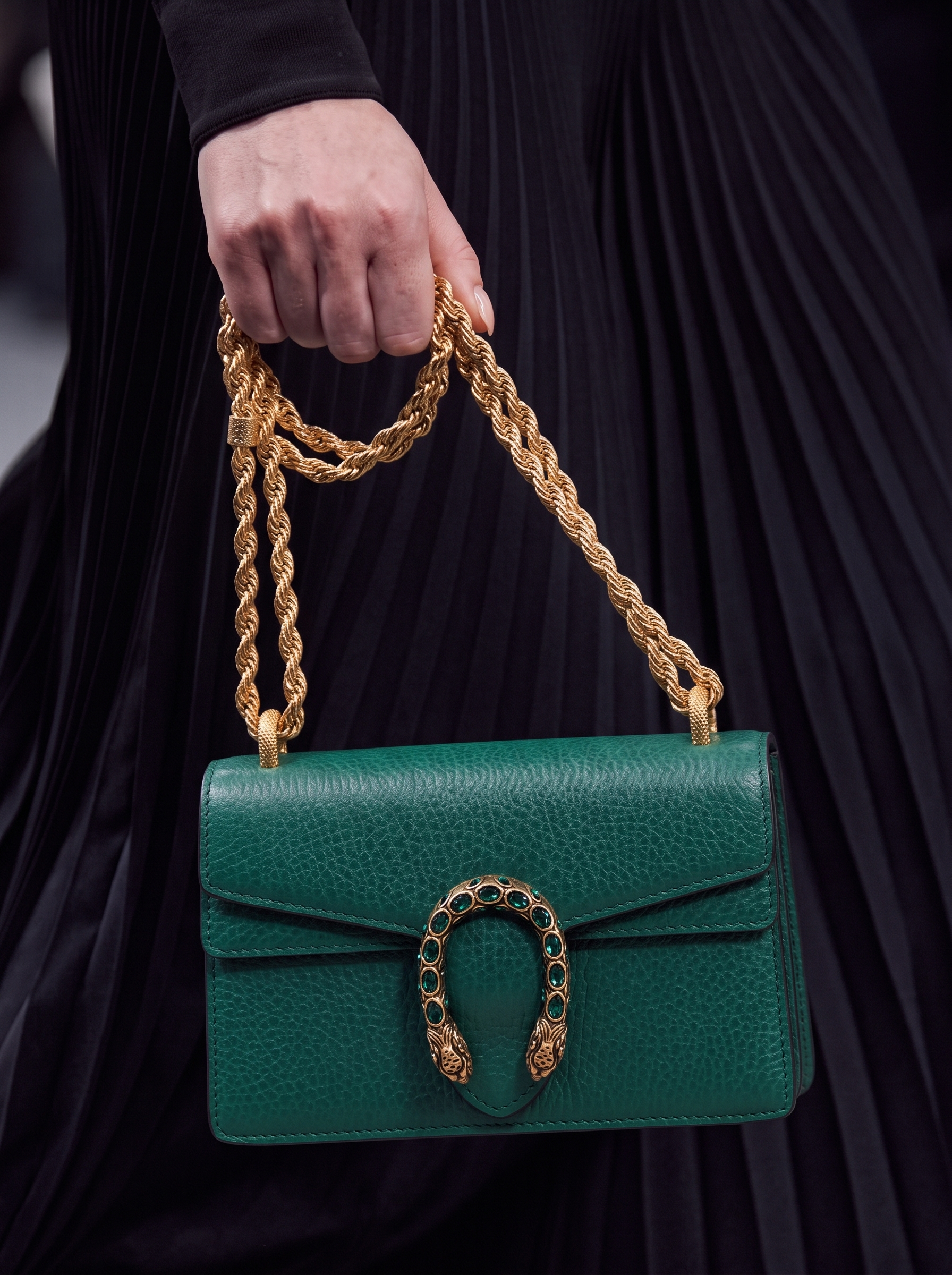 Model carrying an emerald Dollar calfskin Super Mini Dionysus shoulder bag with crystal embellishments
