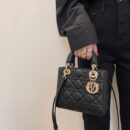Model carrying a black lambskin Medium Lady bag with Cannage quilting and detachable shoulder strap