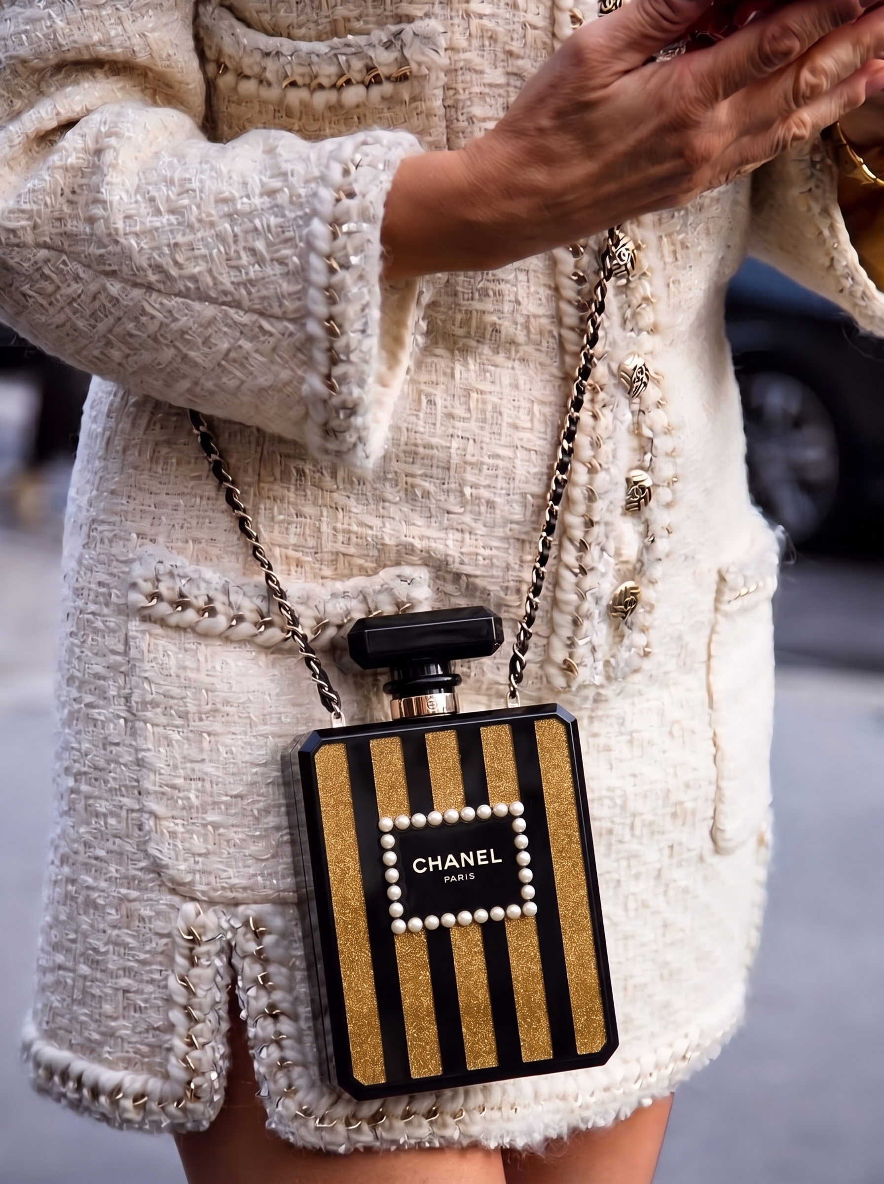 Model carrying the black and gold plexiglass Ch@nel Perfume Bottle Clutch with chain shoulder strap