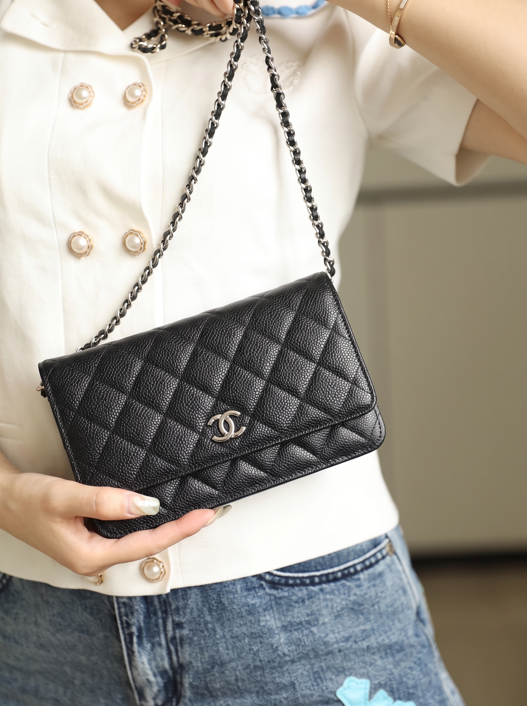 Model carrying the black caviar leather Ch@nel Mini Wallet On Chain with chain shoulder strap