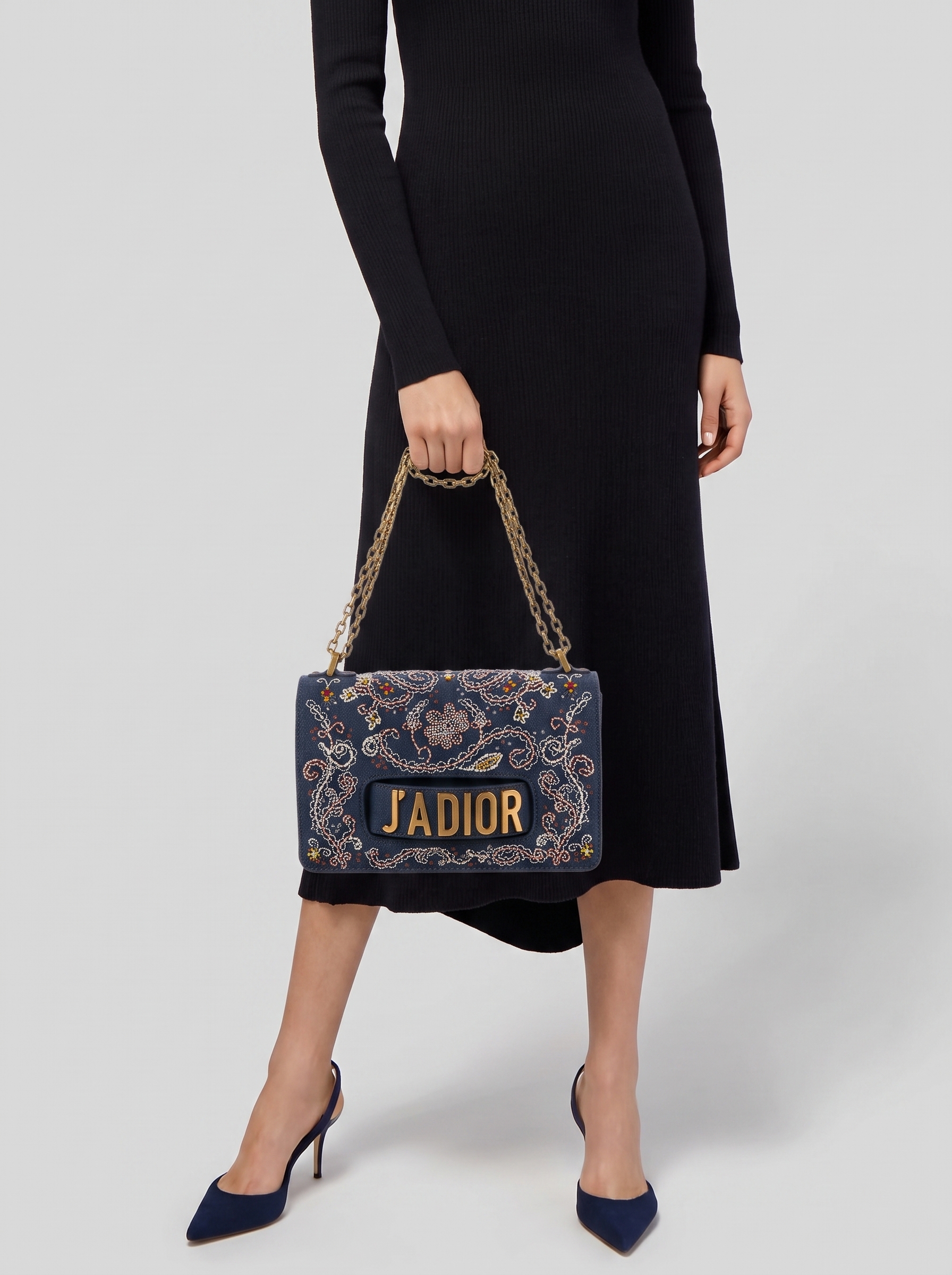 Model carrying the blue denim D!0r J'Adior Chain Flap bag with multicolor embroidery and chain shoulder strap