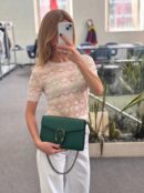 Model carrying the emerald grained calfskin D!0r Mini Dionysus Chain Wallet with chain shoulder strap