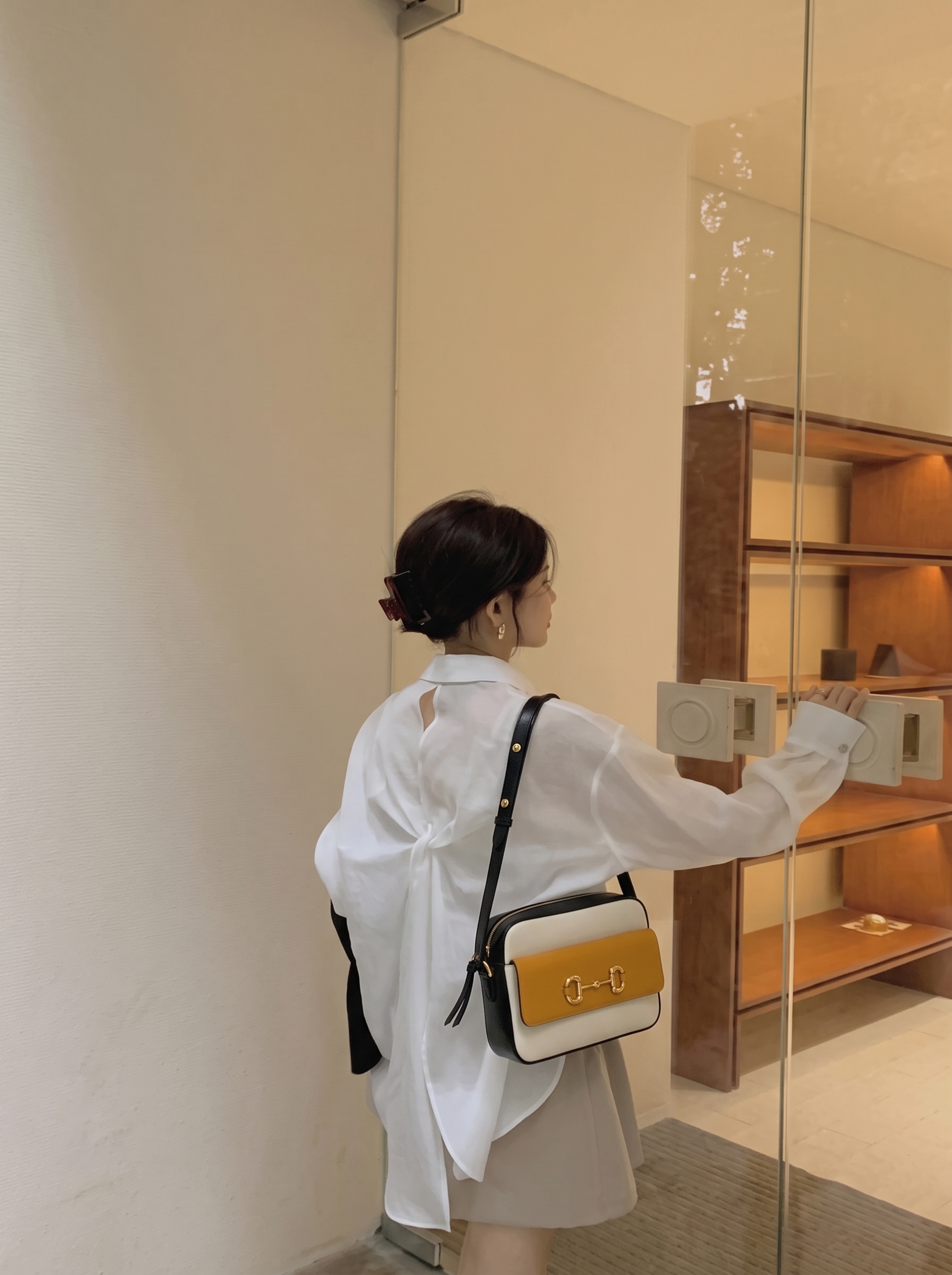 Model carrying the Azalea calfskin Gucc! Small Horsebit 1955 Shoulder Bag in Mystic White and Sun Oil