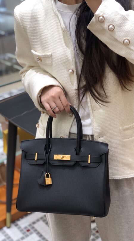 Model carrying the Herme$ Epsom Leather Birkin 30 in Black with gold hardware