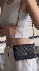 Model carrying the black caviar leather Wallet On Chain with silver-tone chain strap