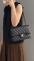 Model carrying the black caviar leather Ch@nel XXL Travel Flap with gold-tone chain straps